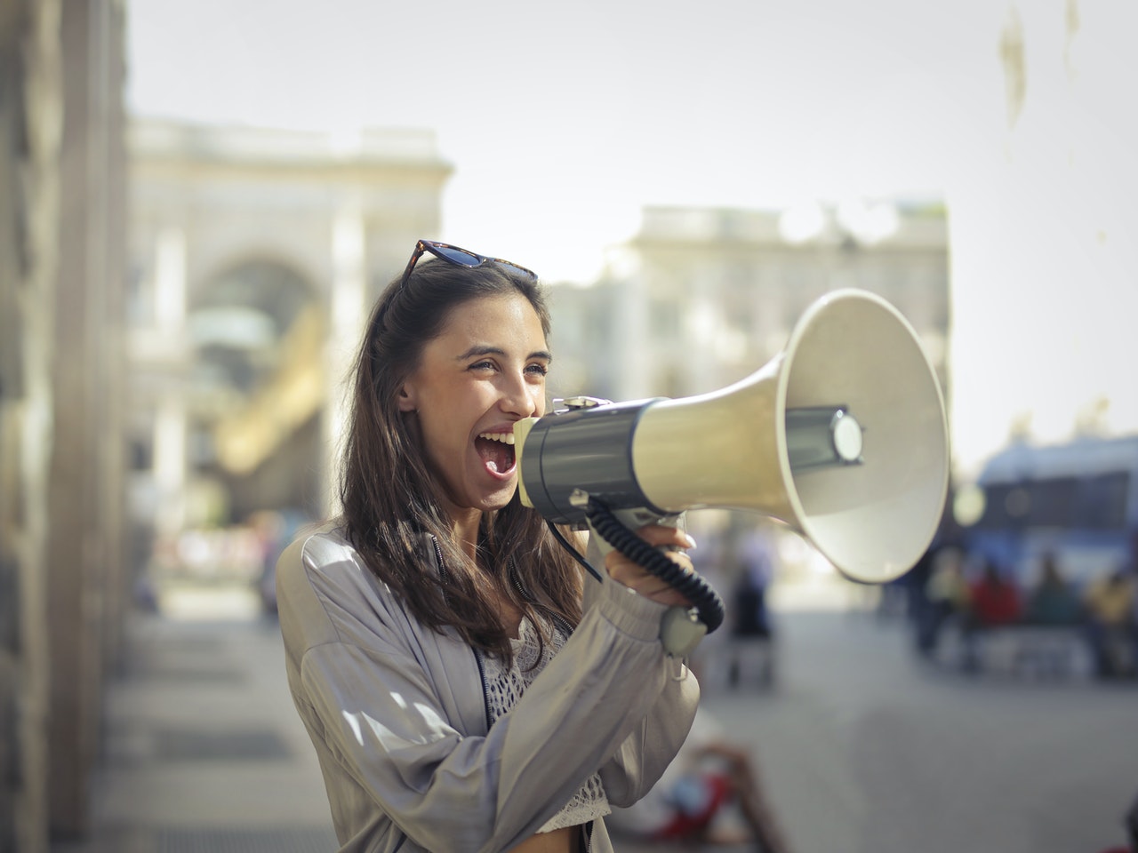 cheerful young woman screaming into megaphone 3761509